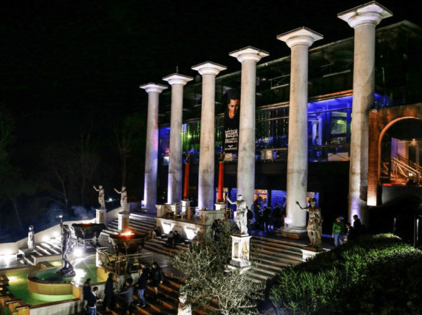 Edificio con colonne e statue illuminate di notte.