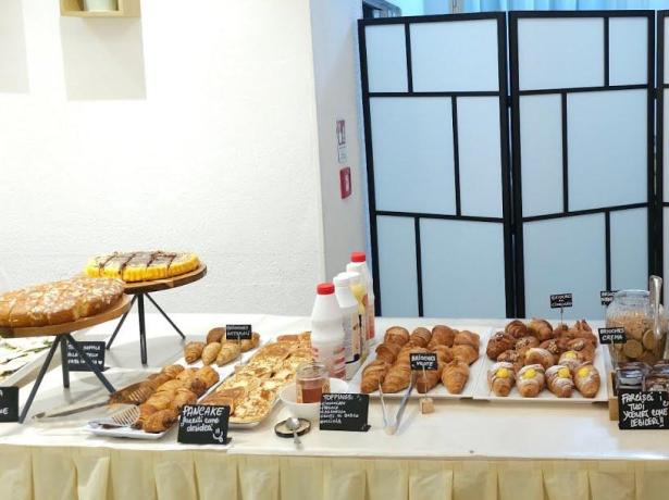 Buffet colazione con dolci, cereali e condimenti vari.